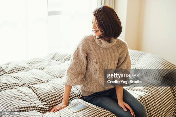 ベッドルームでリラックスした女性 - shiga prefecture ストックフォトと画像