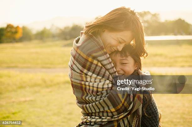 mother hugging daughter in outdoors - family hope stock pictures, royalty-free photos & images