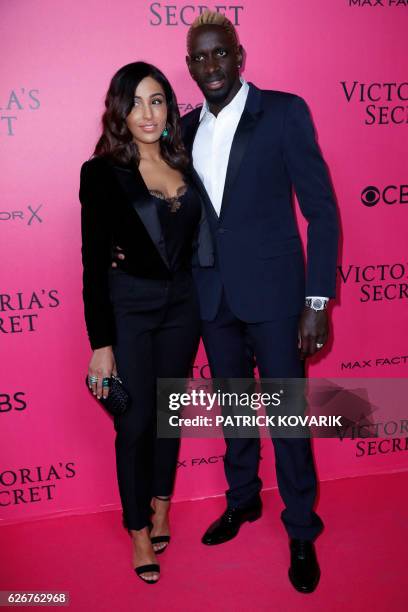 French football player Mamadou Sakho and his wife Majda Sakho pose on the pink carpet upon their arrival for the 2016 Victoria's Secret Fashion Show...