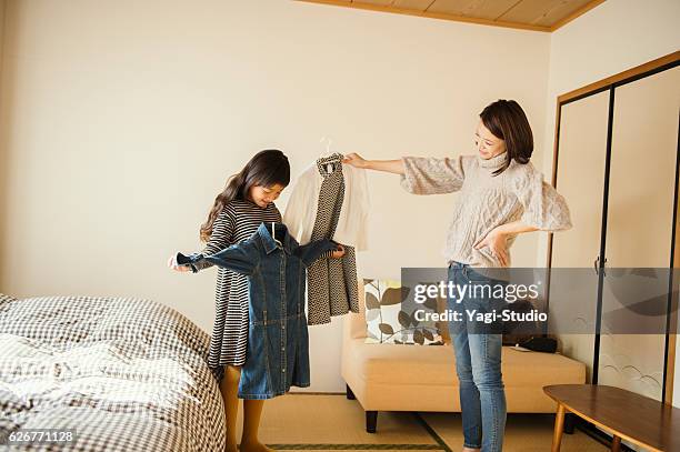 mother and daughter picking out clothes in bedroom - mother and daughter making the bed stock pictures, royalty-free photos & images