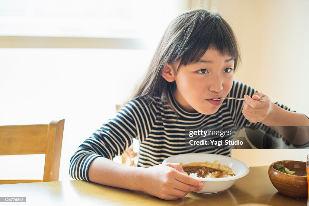 Girl eating lunch in dining room