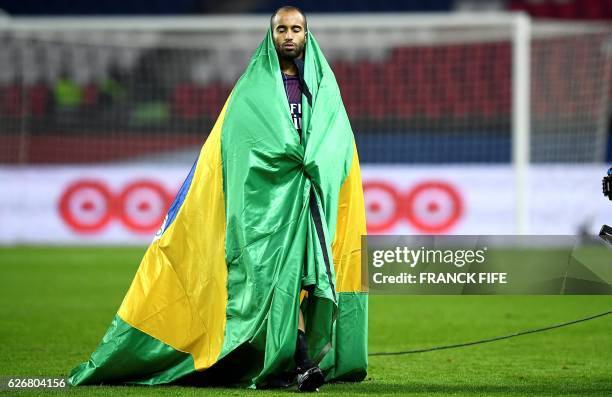 Paris Saint-Germain's Brazilian midfielder Lucas Moura leaves the pitch covered with a Brazilian flag at the end of the French L1 football match...