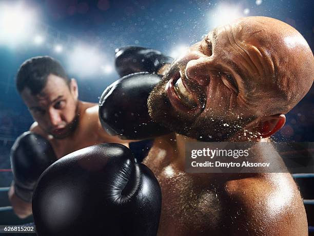 boxing: extremely powerful punch - boxing ropes stockfoto's en -beelden