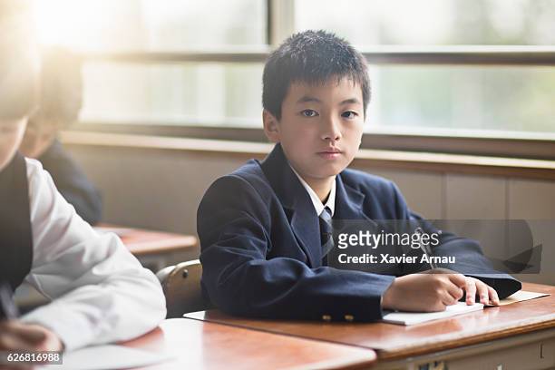 portrait of confident high school boy in classroom - japan 12 years girl stock pictures, royalty-free photos & images