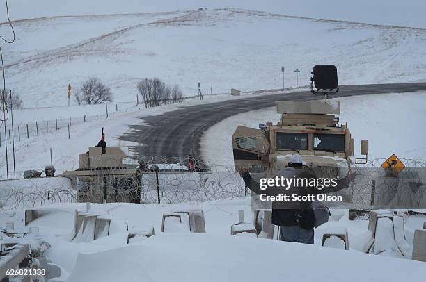 Native American activist confronts police guarding a bridge near Oceti Sakowin Camp on the edge of the Standing Rock Sioux Reservation on November...