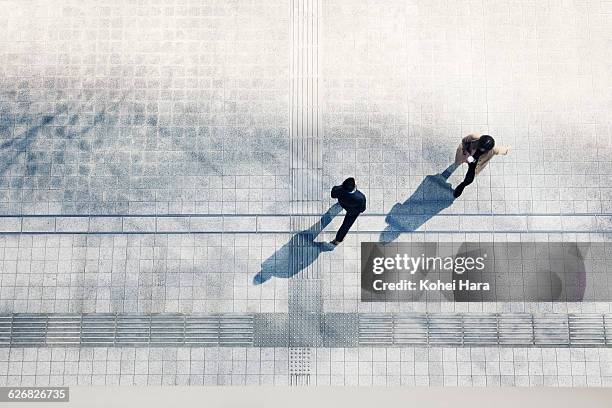 a business man and woman walking - passer devant photos et images de collection