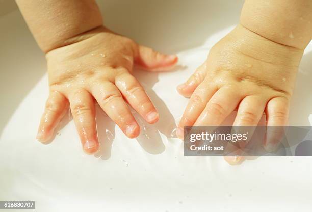hands of baby boy touching in water of washbowl - wash bowl stock pictures, royalty-free photos & images