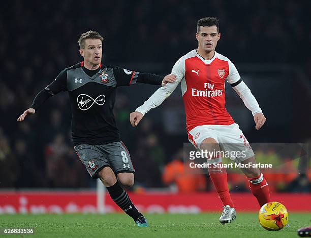 Granit Xhaka of Arsenal breaks past Steven Davis of Southampton during the EFL Quarter Final Cup match between Arsenal and Southampton at Emirates...