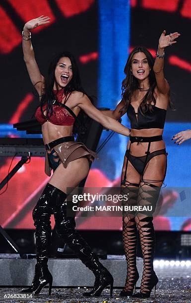 Brazilian model Adriana Lima and Brazilian model Alessandra Ambrosio cheer during the 2016 Victoria's Secret Fashion Show at the Grand Palais in...