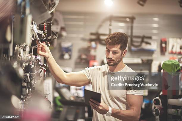 man in bicycle store - sports equipment stock pictures, royalty-free photos & images