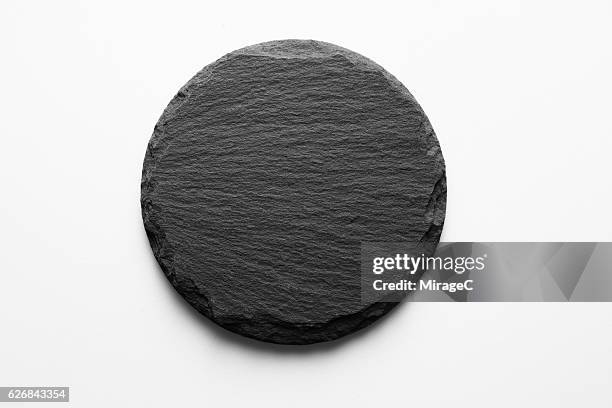 round shape slate stone coaster - black stone background stock-fotos und bilder