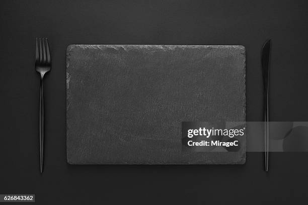 empty black stone tray with eating utensil - grey slate stockfoto's en -beelden