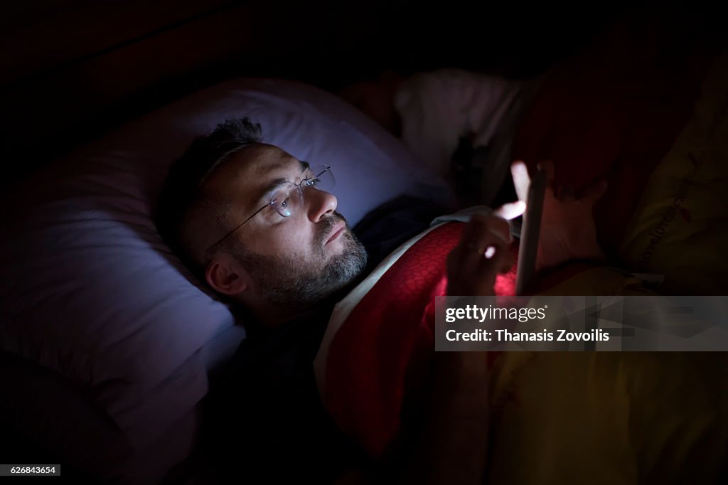 Man using his smart phone in the dark