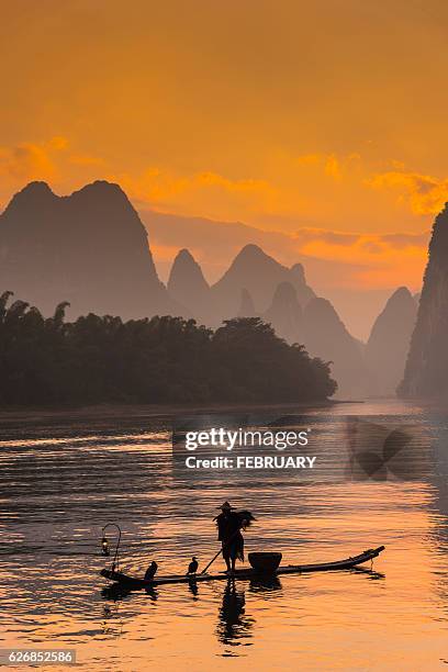silhouette of cormorant fishermen at guilin. - yangshuo stock pictures, royalty-free photos & images