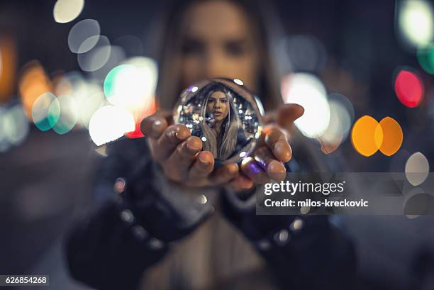 girl holding crystal ball - glass ball stock pictures, royalty-free photos & images