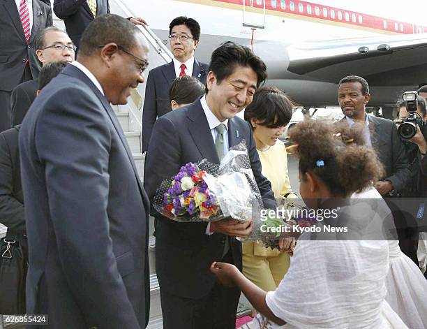 Ethiopia - Japanese Prime Minister Shinzo Abe and his wife Akie receive flowers after arriving at Bole airport in Addis Ababa on Jan. 13, 2014....