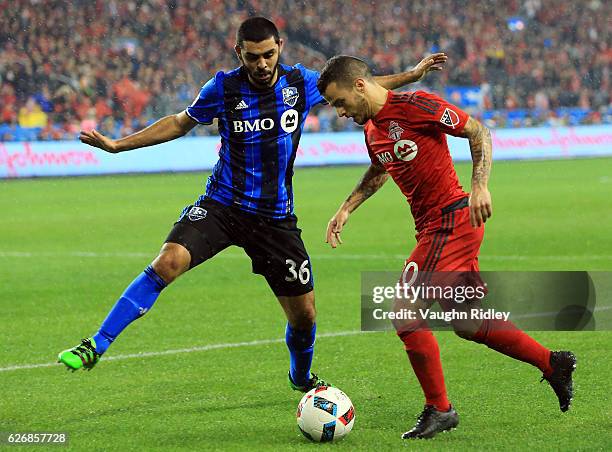 Sebastian Giovinco of Toronto FC battles for the ball with Vctor Cabrera of Montreal Impact during the first half of the MLS Eastern Conference...