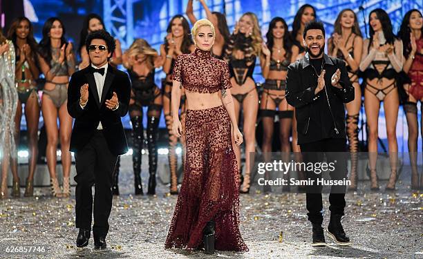 Bruno Mars, Lady Gaga and The Weeknd walk the runway as model look on during the annual Victoria's Secret fashion show at Grand Palais on November...