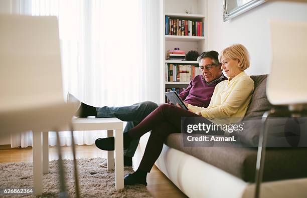 there's so much to do online - couple at table with ipad stockfoto's en -beelden