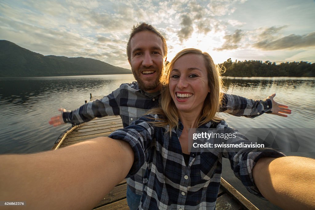 Self portrait of young couple on lake pier