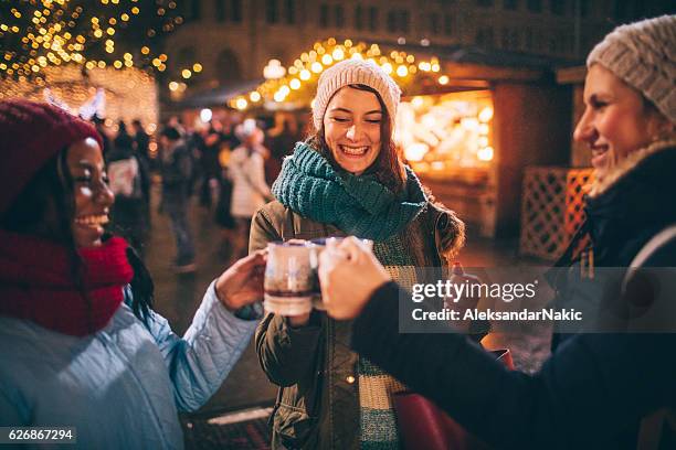 glühwein genussen auf dem weihnachtsmarkt - group wine stock-fotos und bilder