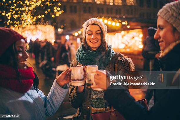 enjoying mulled wine on christmas market - mulled wine stock pictures, royalty-free photos & images