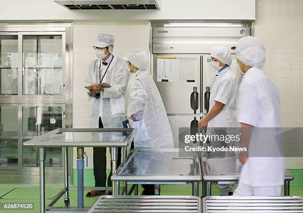 Japan - Local health officials examine an elementary school kitchen in Hamamatsu, Shizuoka Prefecture, on Jan. 17 after 905 students at 14 schools in...