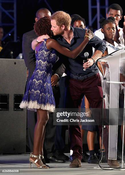 Prince Harry hugs Jamilla Sealy attend a Golden Anniversary Spectacular Mega Concert at the Kensington Oval Cricket Ground on day 10 of an official...