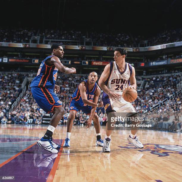 Forward Tom Gugliotta of the Phoenix Suns dribbles around forward Kurt Thomas and point guard Mark Jackson of the New York Knicks during the NBA game...
