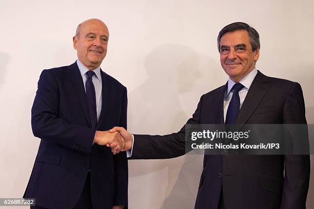 Winner of the Primary Election of the right wing Les Republicains Francois Fillon and his opponent Alain Juppe exchange an handshake publicly after...