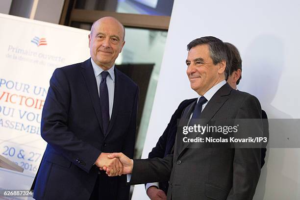 Winner of the Primary Election of the right wing Les Republicains Francois Fillon and his opponent Alain Juppe exchange an handshake publicly after...