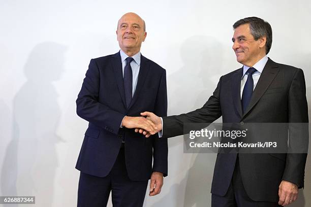 Winner of the Primary Election of the right wing Les Republicains Francois Fillon and his opponent Alain Juppe exchange an handshake publicly after...