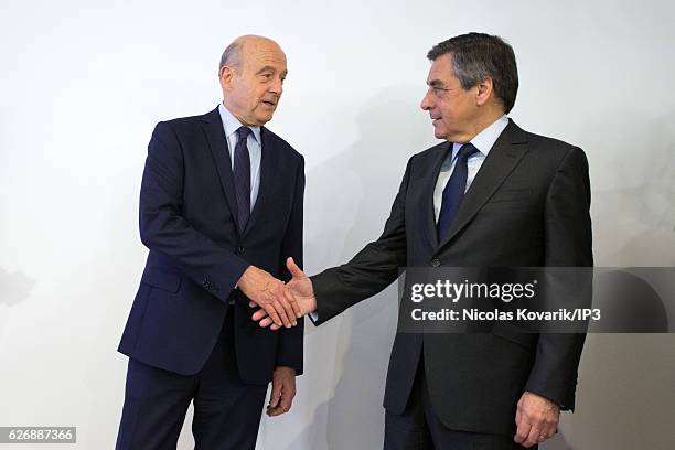 Winner of the Primary Election of the right wing Les Republicains Francois Fillon and his opponent Alain Juppe exchange an handshake publicly after...