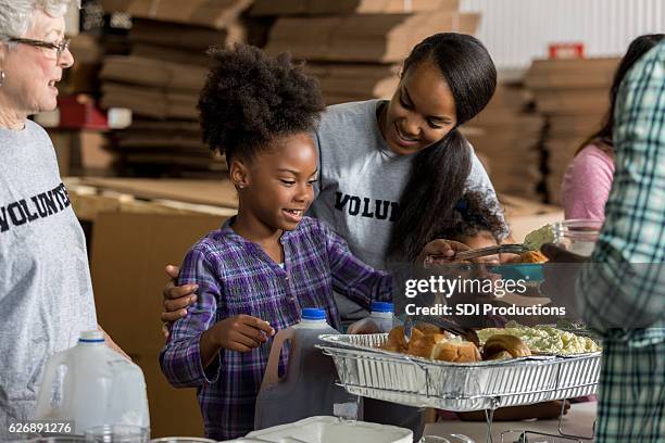 vielfältige freiwillige servieren essen in suppenküche - father and children volunteering stock-fotos und bilder