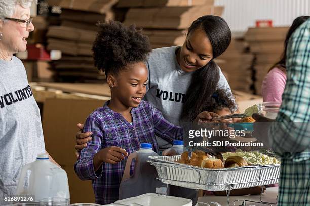 diverse volunteers serve food in soup kitchen - family health club stock pictures, royalty-free photos & images