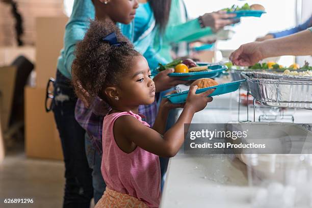 pretty little girl in line at soup kitchen - homeless family stock pictures, royalty-free photos & images