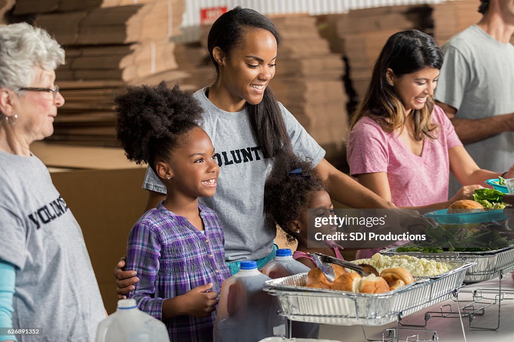 Diverse family volunteers together in soup kitchen