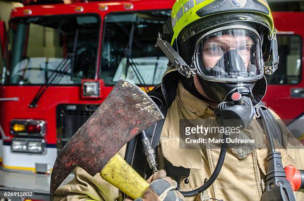 headshot on fireman wearing full protection equipment and truck - fireman axe stock pictures, royalty-free photos & images