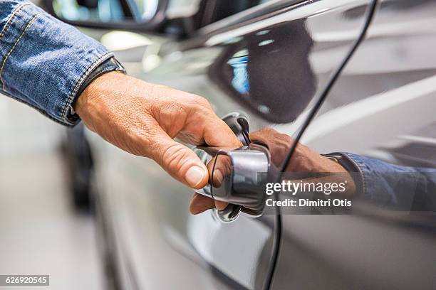 man's hand on grey car door handle - vehicle door stock pictures, royalty-free photos & images