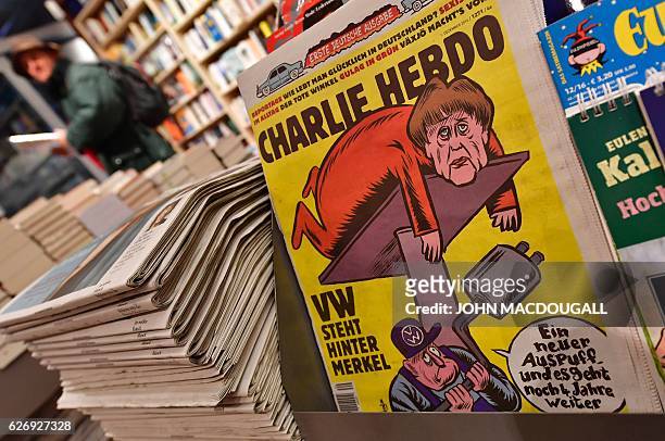 The first issues of the German version of French satirical weekly Charlie Hebdo are for sale at a newsstand in Berlin on December 1, 2016. / AFP /...