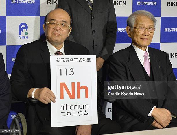 Kyushu University Professor Kosuke Morita , head of a team of researchers who created the atomic element 113, holds up the name of the element...