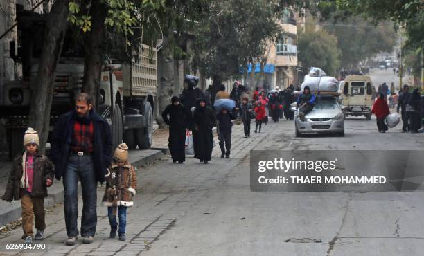 Syrian residents of eastern rebel-held parts of Aleppo walk through the Kadi Askar district as they leave their homes for a safer place in a distinct...