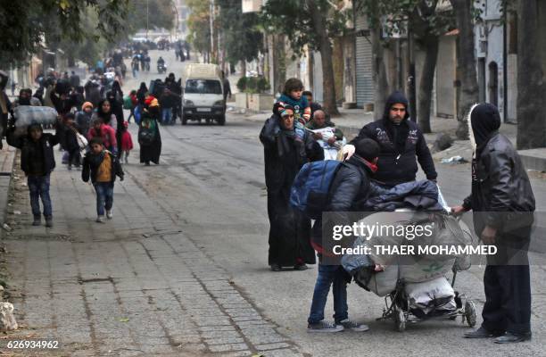 Syrian residents of eastern rebel-held parts of Aleppo walk through the Kadi Askar district as they leave their homes for a safer place in a distinct...