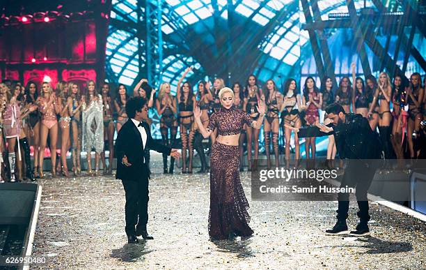 Bruno Mars, Lady Gaga and The Weeknd walk the runway as model look on during the annual Victoria's Secret fashion show at Grand Palais on November...