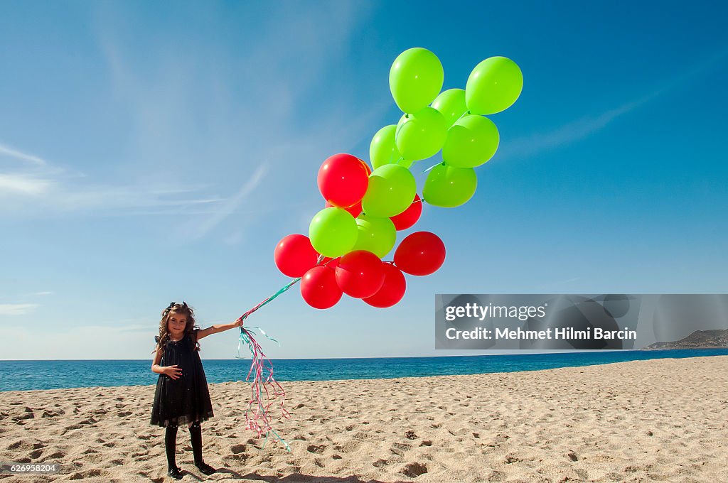 Cute girl having fun with ballons on her birthday