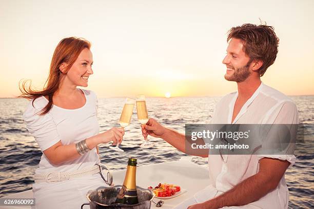 cheerful couple sea sunset dinner - ship's bow stock pictures, royalty-free photos & images