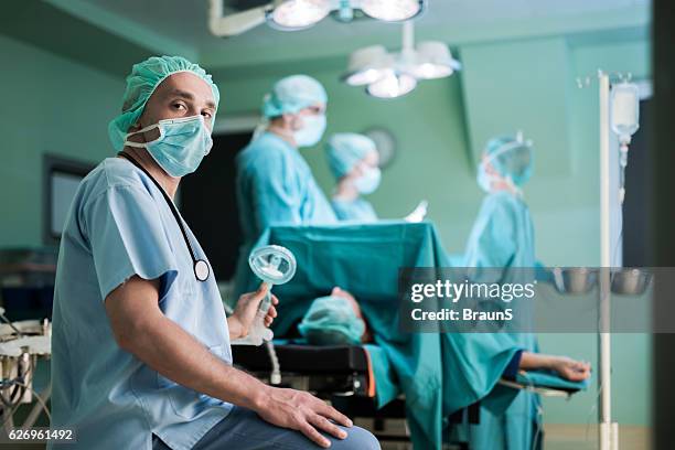 mid adult anesthesiologist during surgery in operating room. - anesthesia stock pictures, royalty-free photos & images