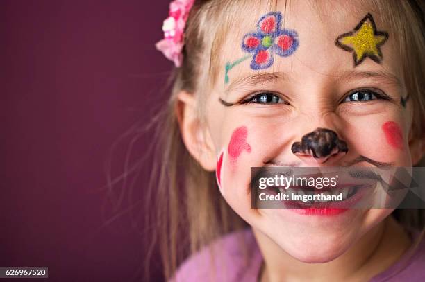 smiling little girl with a painted face - geschminkt gezicht stockfoto's en -beelden