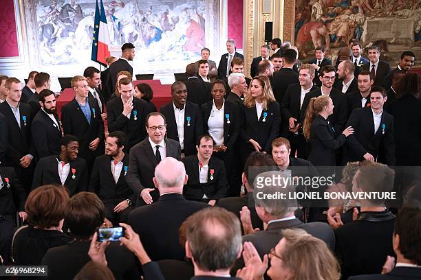 French President Francois Hollande stands amongst Olympic and Paralympic athletes after awarding them the Legion of Honour at the Elysee Presidential...
