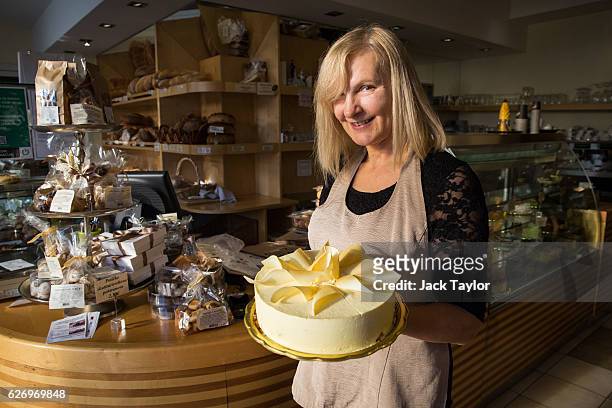 Bakery worker Jelenc Darja is pictured holding a white chocolate mousse cake with gold decoration called 'Melanija' created in honour of Melania...